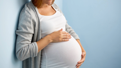 Junge Frau hält sich ihren schwangeren Bauch