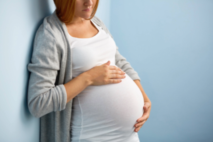 Junge Frau hält sich ihren schwangeren Bauch