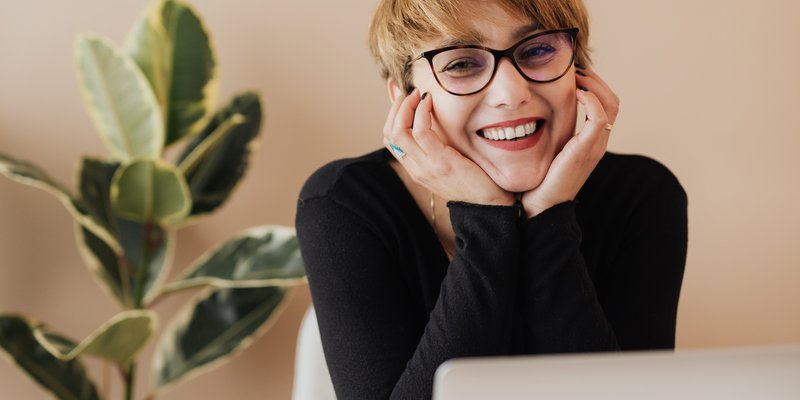 Eine junge Mitarbeiterin arbeitet mit Arbeitslaptop im Homeoffice